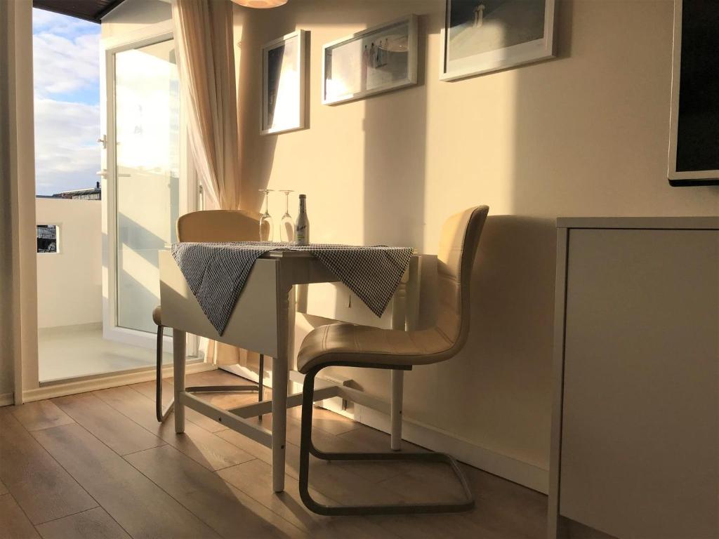 a dining room with a table and chairs and a window at Ferienwohnung Strandmarie, Haus Loreley, App. 14 in Sankt Peter-Ording