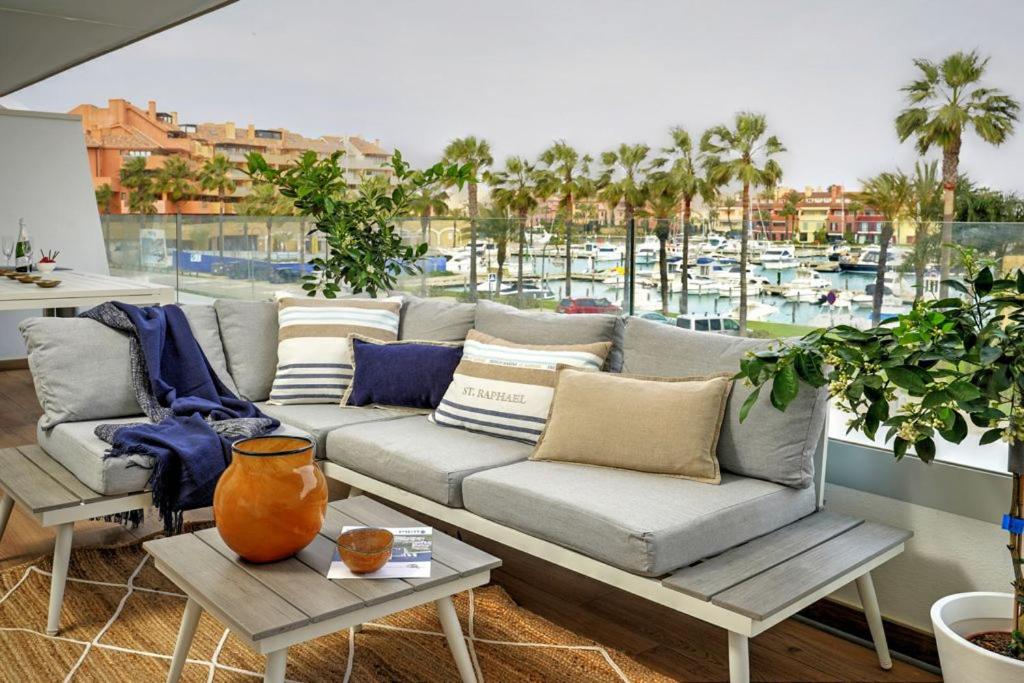 a living room with a couch and a view of a harbor at NEW & Modern Apartment - Marina, Sotogrande in Sotogrande
