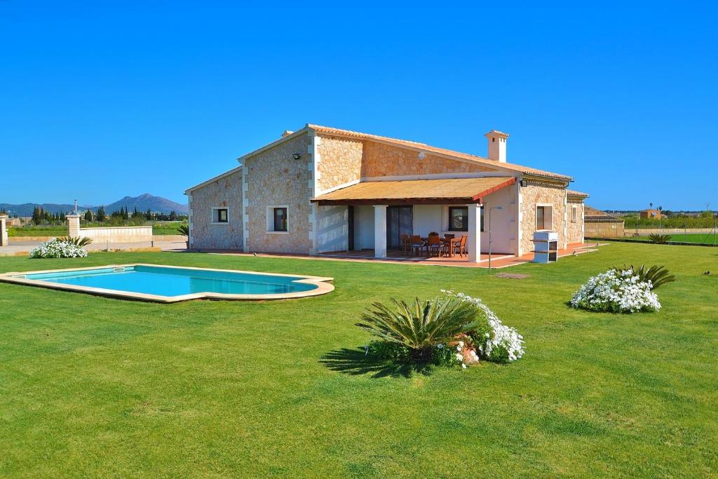 een stenen huis met een zwembad in een tuin bij Villa Flor de Sal 178 by Mallorca Charme in Muro