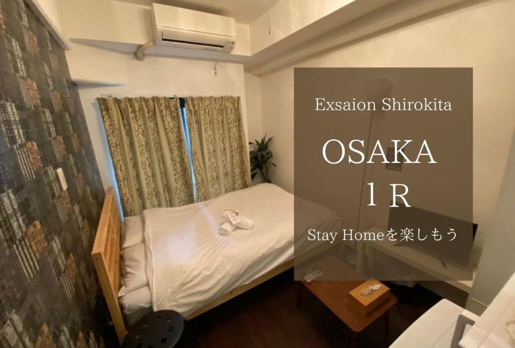 a small bedroom with a bed in a room at Exsaison Shirokita 212 in Osaka
