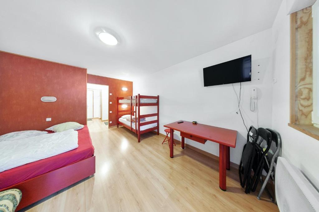 um quarto com uma cama, uma secretária e uma televisão em Studio avec terrasse amenagee a Gerardmer em Gérardmer