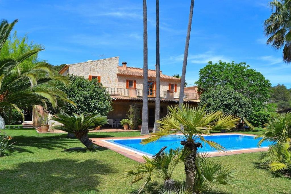 ビニサレムにあるVilla Can Bast 106 by Mallorca Charmeのヤシの木とスイミングプールのある家