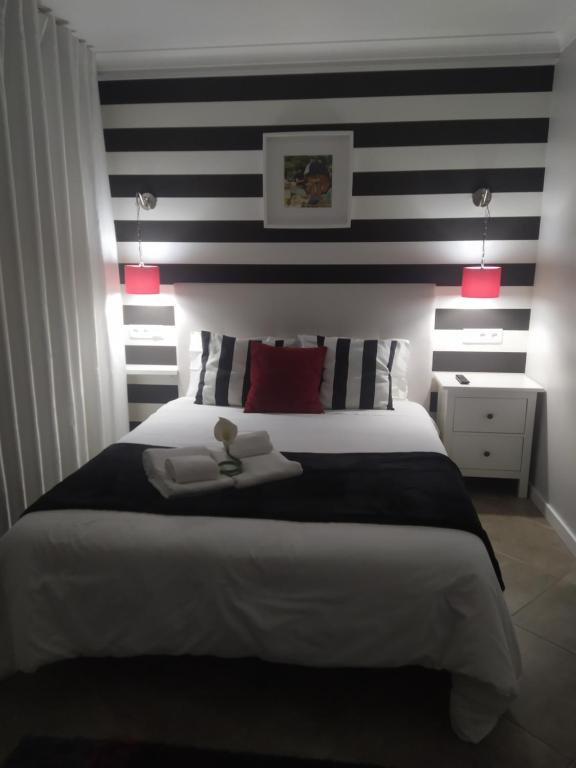 a bedroom with a large bed with a black and white striped wall at FerhouseDreams-Praia in Nazaré