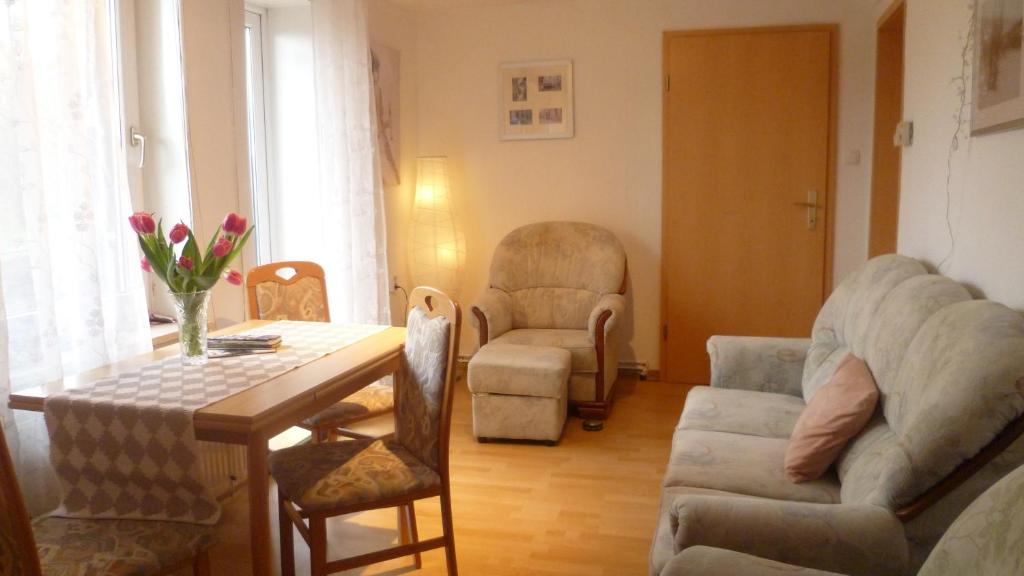ein Wohnzimmer mit einem Tisch, Stühlen und einem Sofa in der Unterkunft Harzurlaub Heyder in Elbingerode