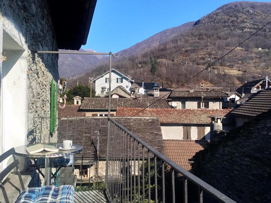 uma varanda com uma mesa e vista para uma montanha em Appartement "Casa Luigi" em Intragna