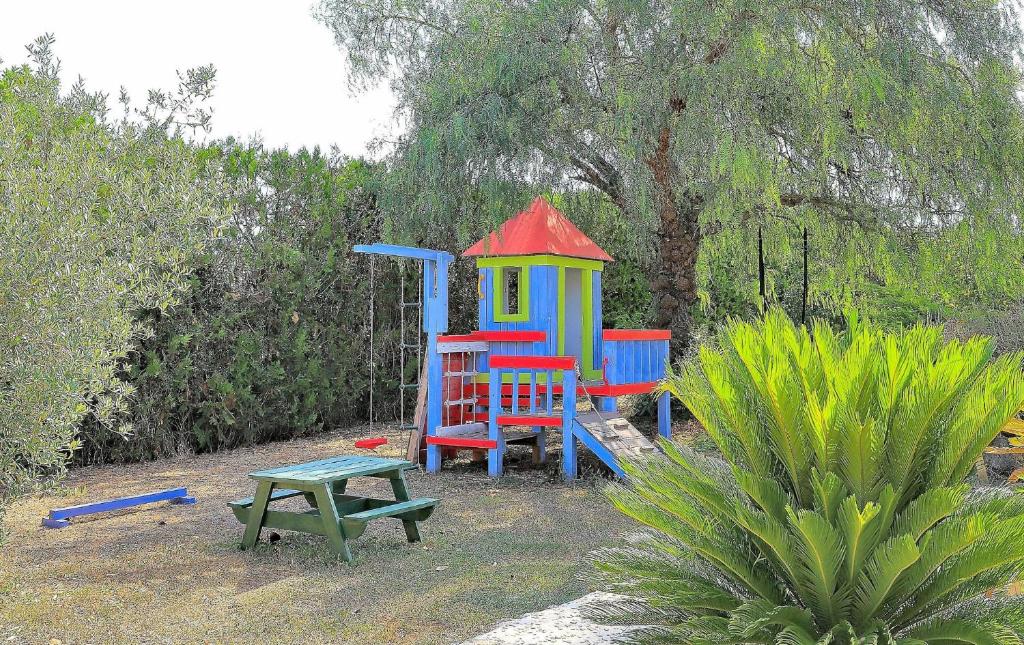 a playground with a play house and a bench at Finca Son Rossinyol 128 by Mallorca Charme in Sineu
