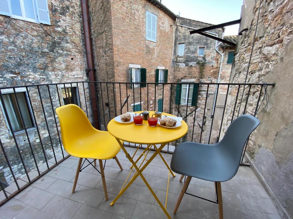 a yellow table and two chairs on a balcony at VANNUCCI 71 APT in Perugia