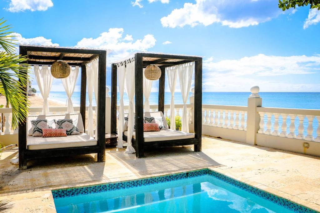 um resort com duas camas ao lado de uma piscina em Tres Sirenas Beach Inn em Rincon
