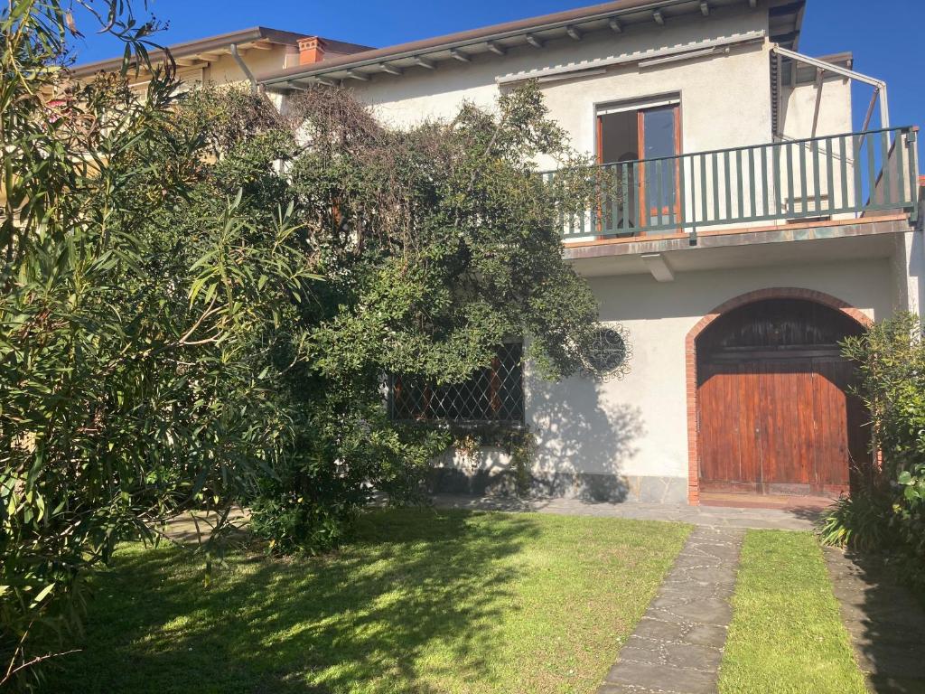 a house with a wooden door and a yard at Villa Lucia in Marina di Pietrasanta