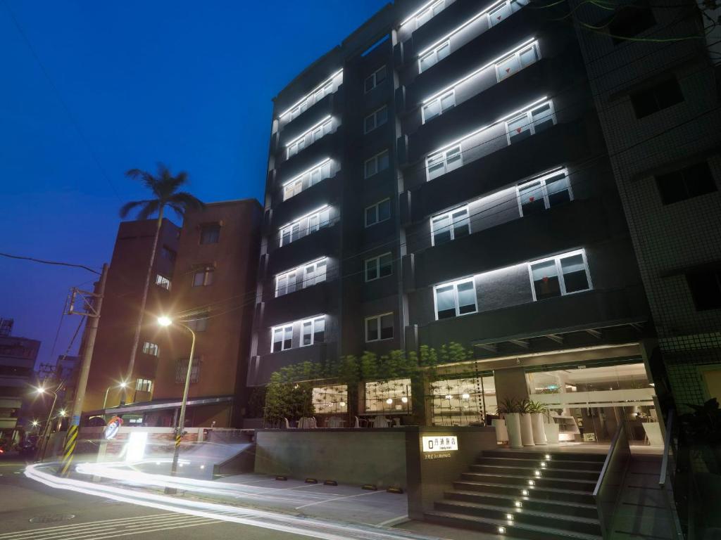 a city street with two tall buildings at night at Dandy Hotel - Tianmu Branch in Taipei