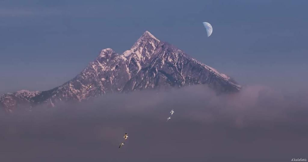 a mountain in the middle of a body of water at House Chrysoula Mitsokopi in Sarti
