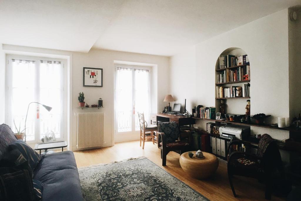 un salon avec un canapé et une étagère dans l'établissement Bright And Charming F2 Near Republique, à Paris