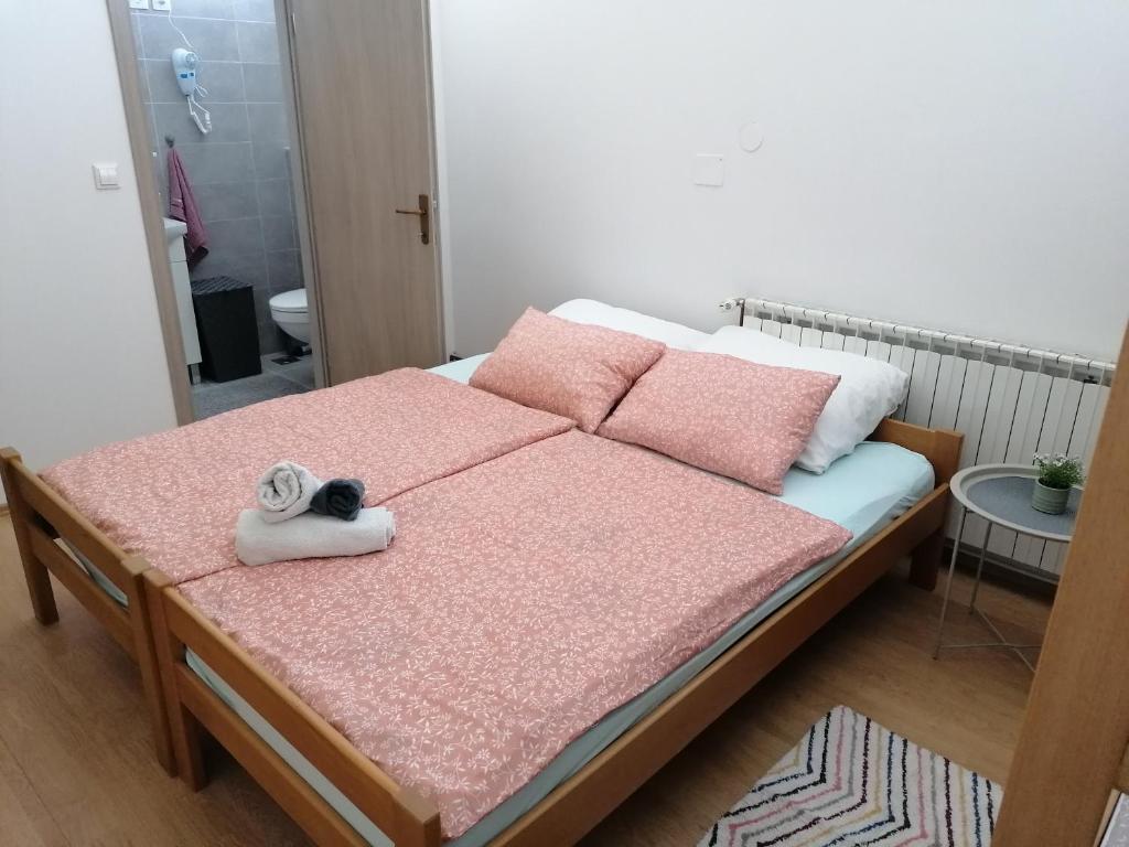 ein Bett mit rosa Kissen und Handtüchern darauf in der Unterkunft Hostel Poslon in Krapina