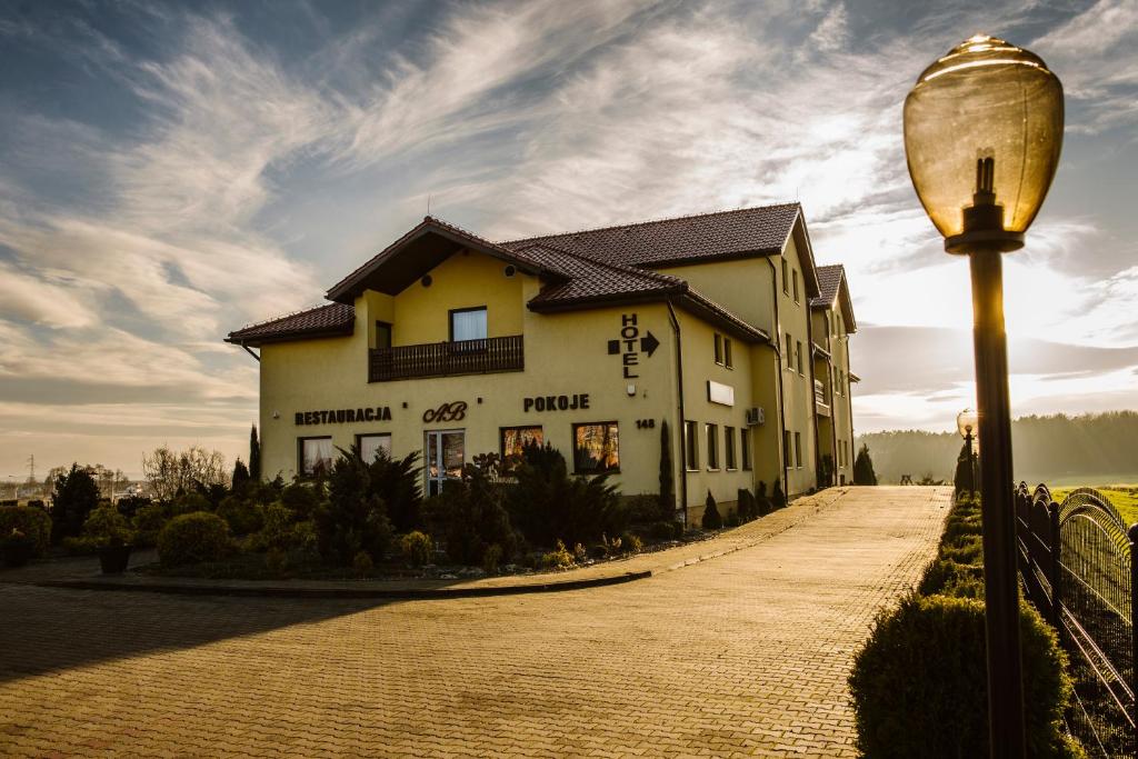 um edifício numa estrada ao lado de uma luz de rua em Hotel AB em Tychy