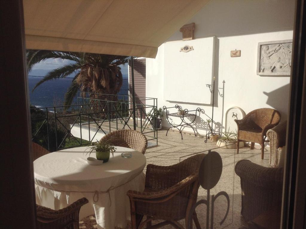 un patio con mesas y sillas y vistas al océano en Akrotiri Hotel, en La Canea