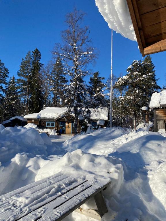 una panchina coperta di neve di fronte a una casa di Joängets Fjällgård a Sälen