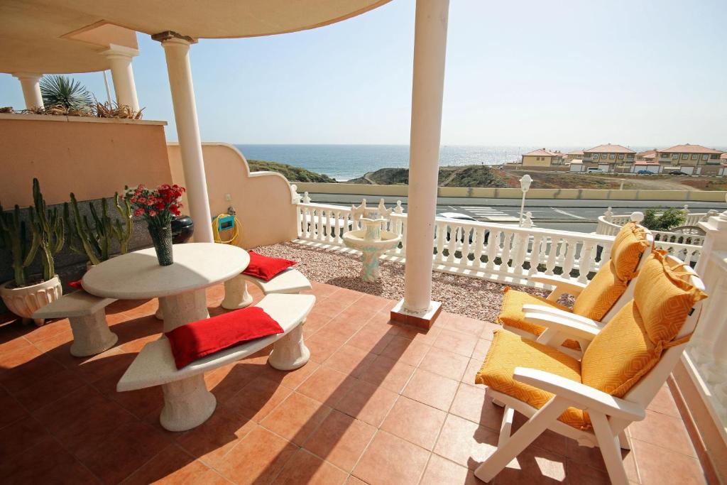 エル・メダノにあるLAS DUNAS 9 by RENTMEDANO pretty beach front boutique villa with ocean view, pool and WiFiの海を望むバルコニー(テーブル、椅子付)