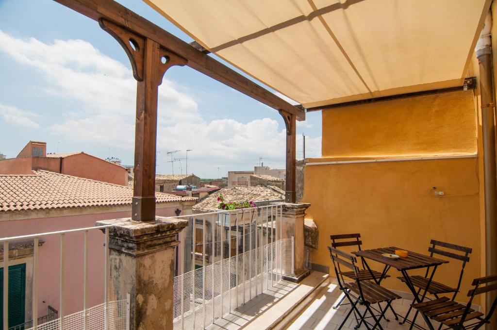 patio con mesa y sillas en el balcón en Case Vacanze Ducezio en Noto