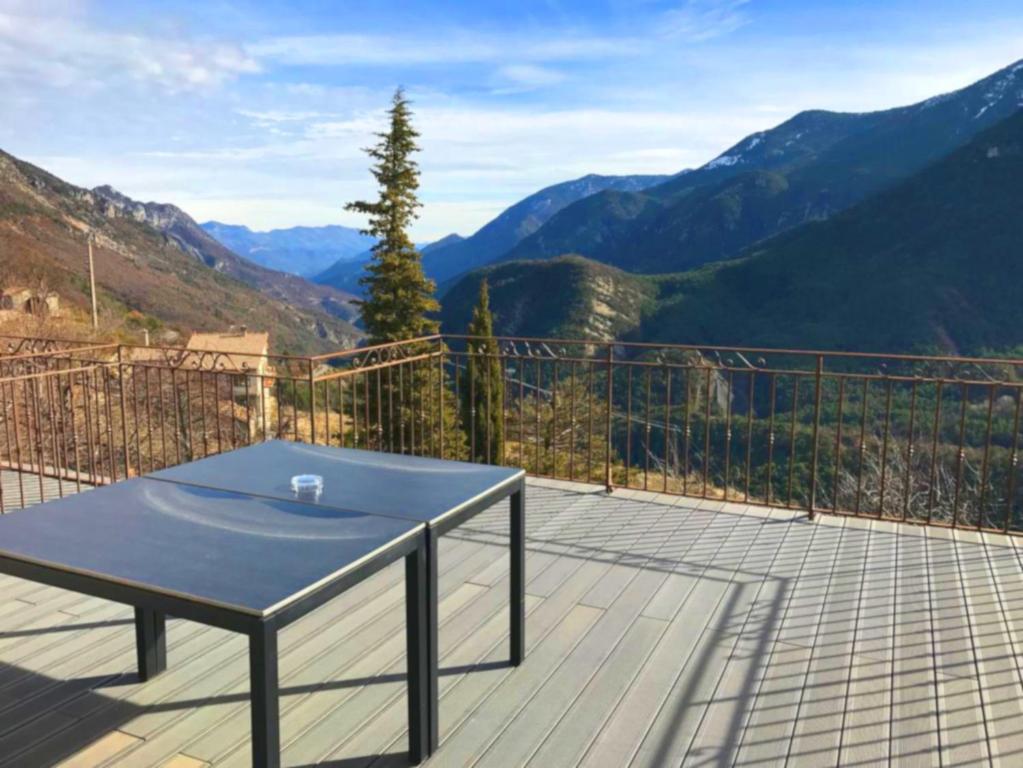 a table on a deck with a view of mountains at Colchique in Le Mas