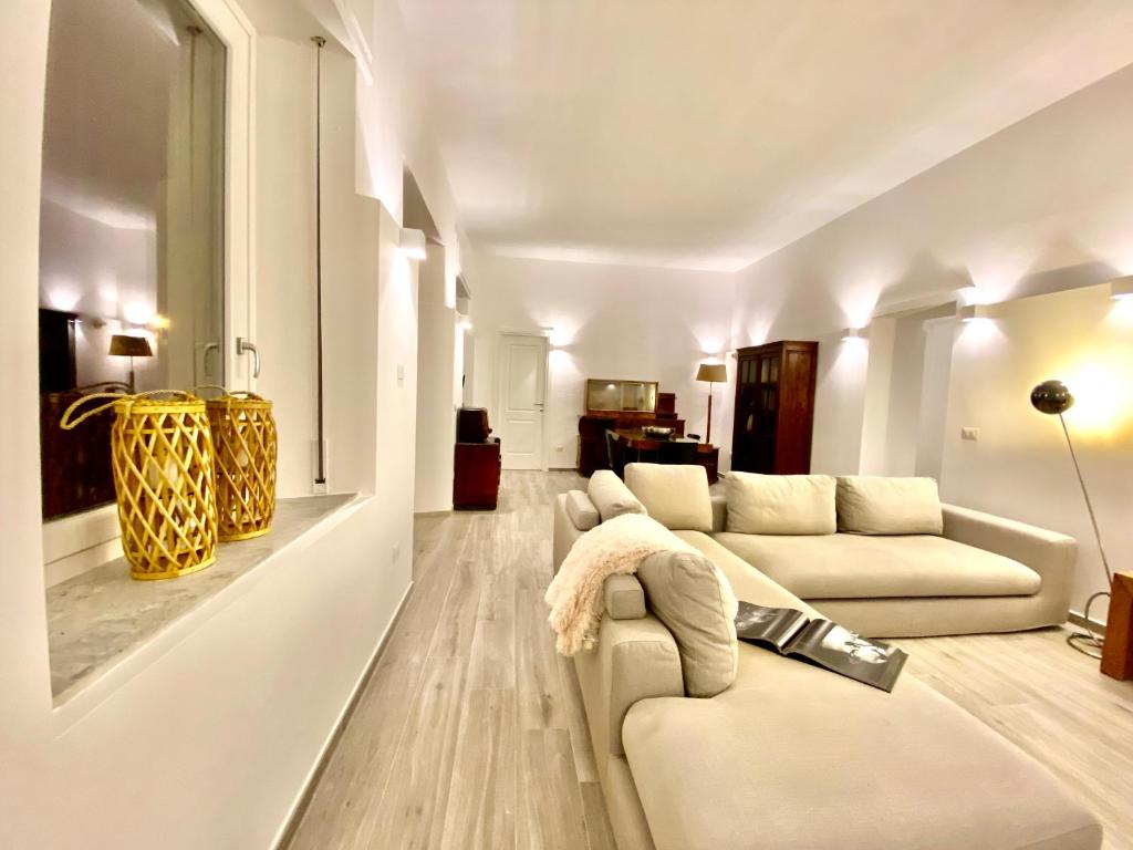 una sala de estar con 2 sofás blancos y un jarrón amarillo en La casa della Posta - San Gregorio, en San Gregorio