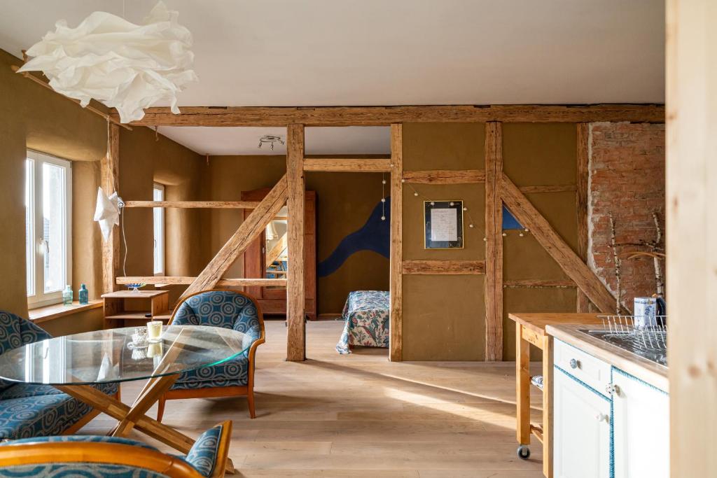 a kitchen with a glass table and blue chairs at Storchenblick in Zarnewanz