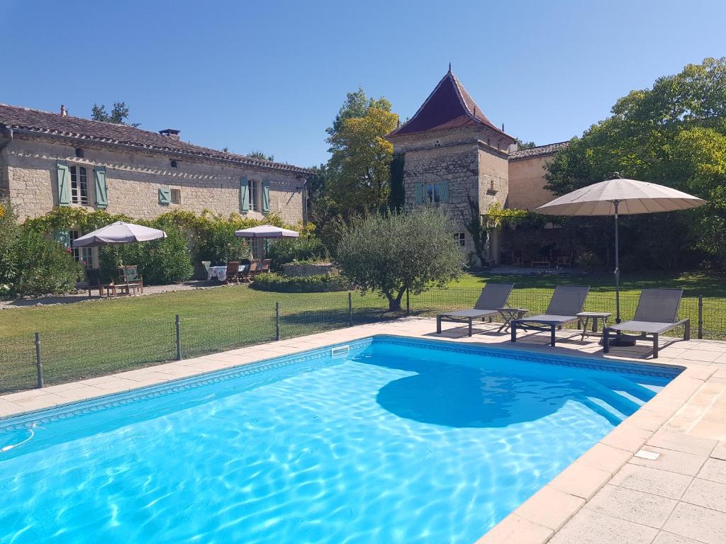 una piscina en un patio con 2 sillas y una casa en Villa Mas, en Cestayrols
