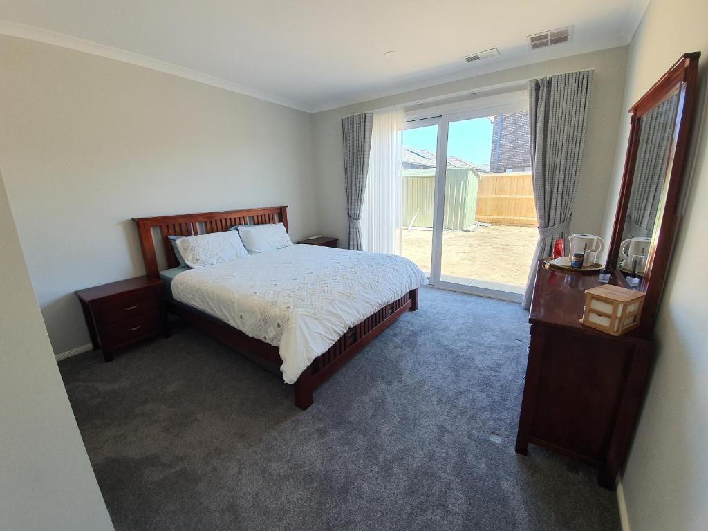 a bedroom with a bed and a large window at Charm Villa in Clyde North