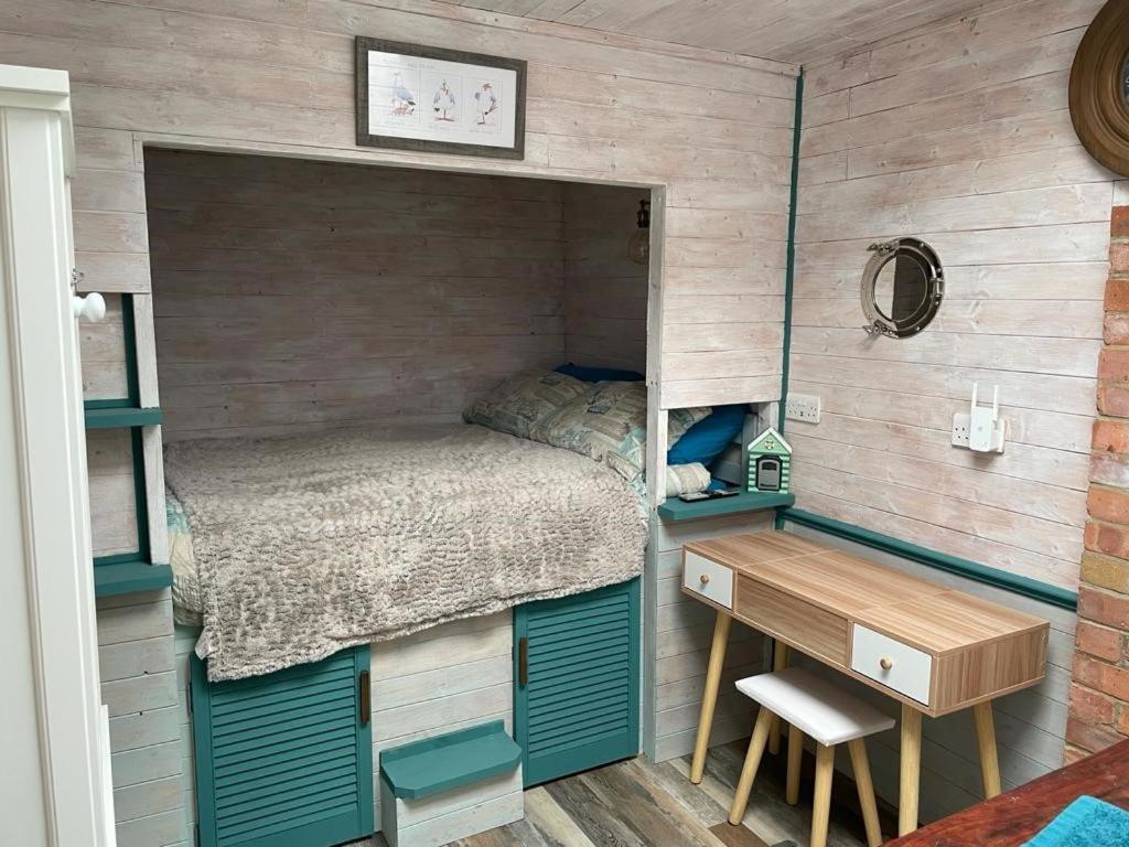 Habitación pequeña con cama y escritorio. en The Old Garage, en Saltdean