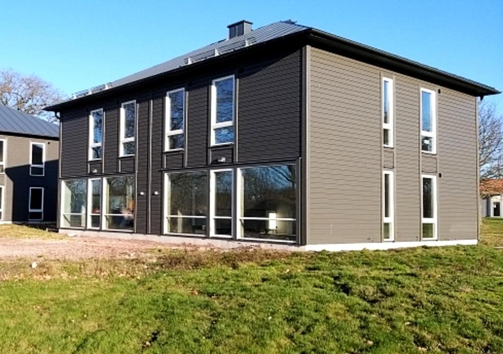 uma casa com um exterior preto e cinzento em Saxnäs Ferieboende L Jan em Färjestaden