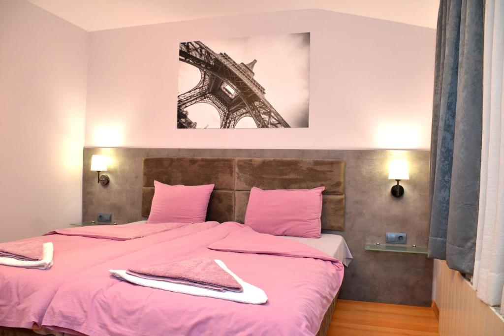 ein Schlafzimmer mit einem rosa Bett mit Handtüchern darauf in der Unterkunft Стаи за Гости Тони и Крис in Dewin