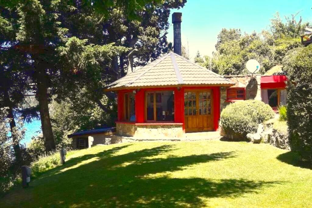 um gazebo vermelho no quintal de uma casa em A orillas del lago, un espacio para tu tranquilidad em San Carlos de Bariloche