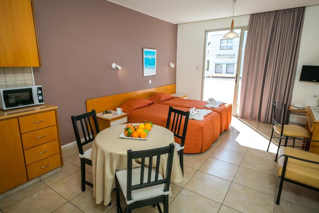 a bedroom with a bed and a table with fruit on it at Crystallo Apartments in Paphos