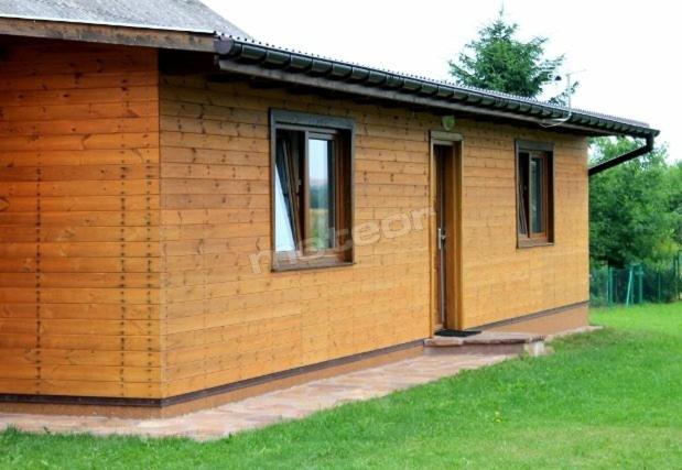 ein kleines Holzhaus mit einem Fenster und einer Tür in der Unterkunft Domek letniskowy Smreczyny Bobra in Jeziorko