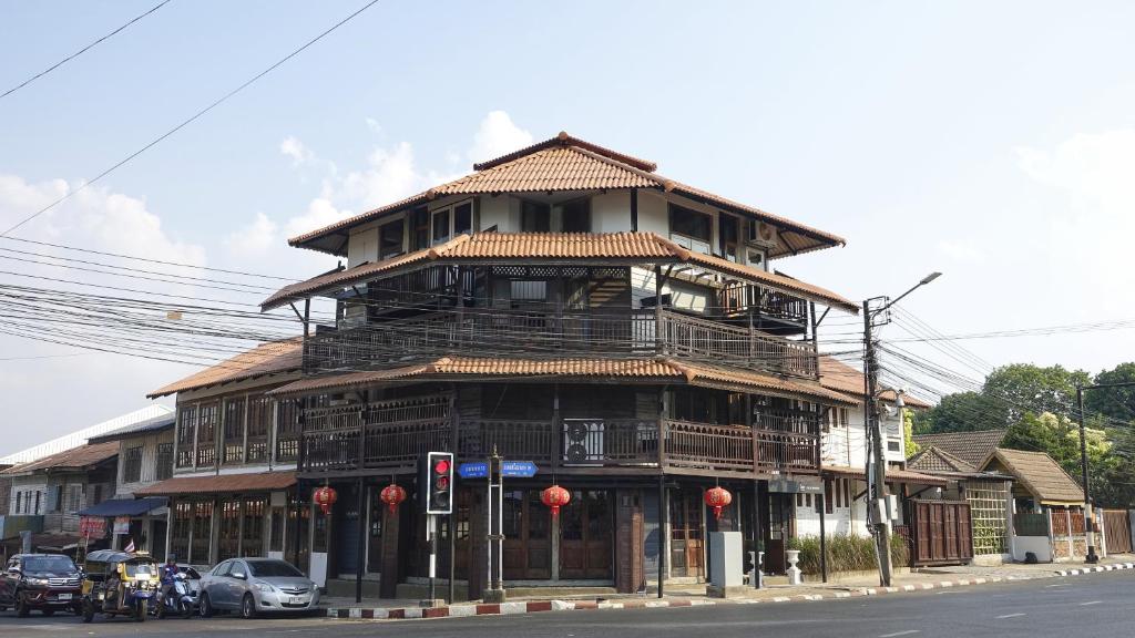 a large wooden building on the corner of a street at Velawarin Hotel in Ubon Ratchathani