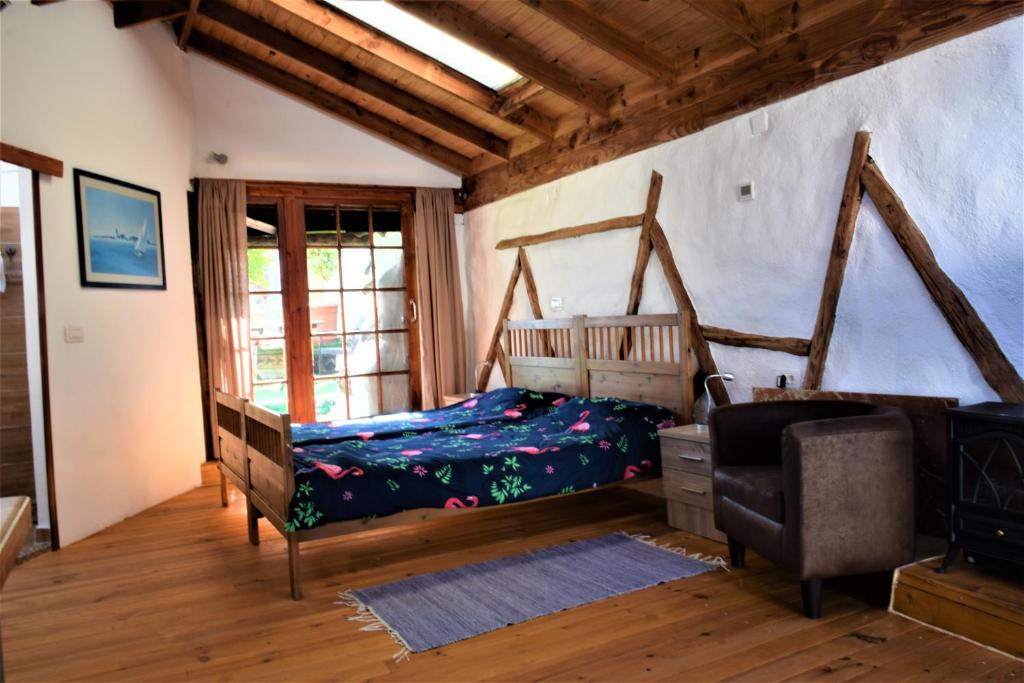 een slaapkamer met een bed en een stoel in een kamer bij Finca Casa Madera in Icod de los Vinos