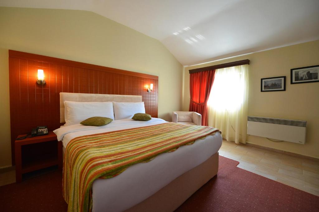 a bedroom with a large bed and a window at City Hotel in Tirana