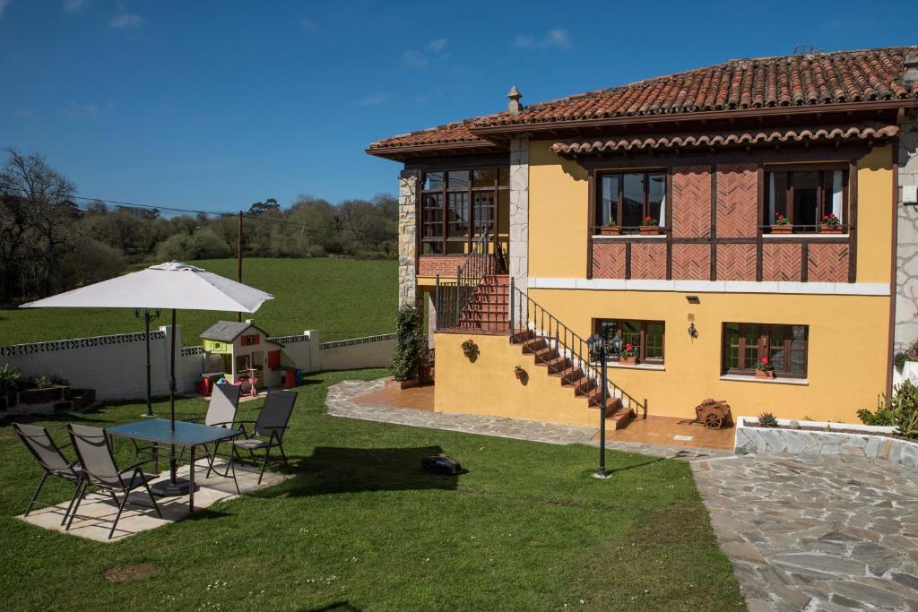 una casa con mesa y sillas en el patio en Apartamentos Alegría en Santillana del Mar