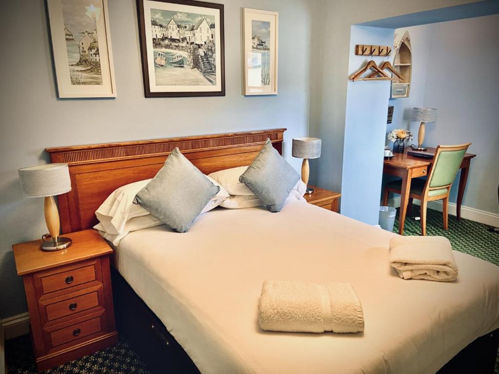 a bedroom with a large bed and a desk at The Fleur De Lis in Sandwich