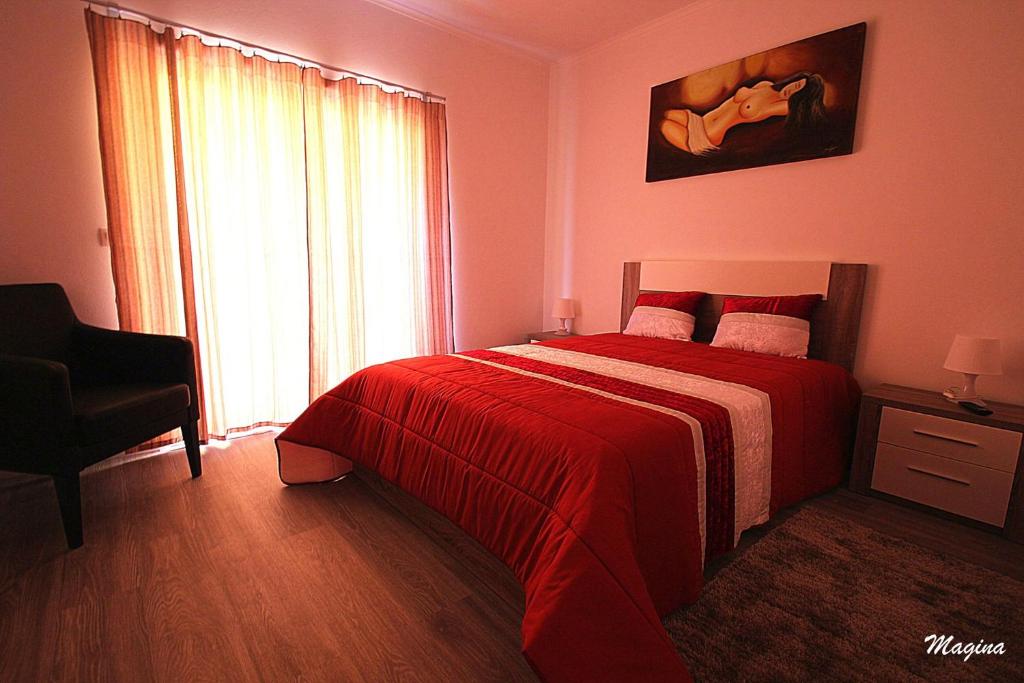 オルタにあるBaía dos Golfinhos Hortaのベッドルーム1室(赤いベッド1台、窓付)