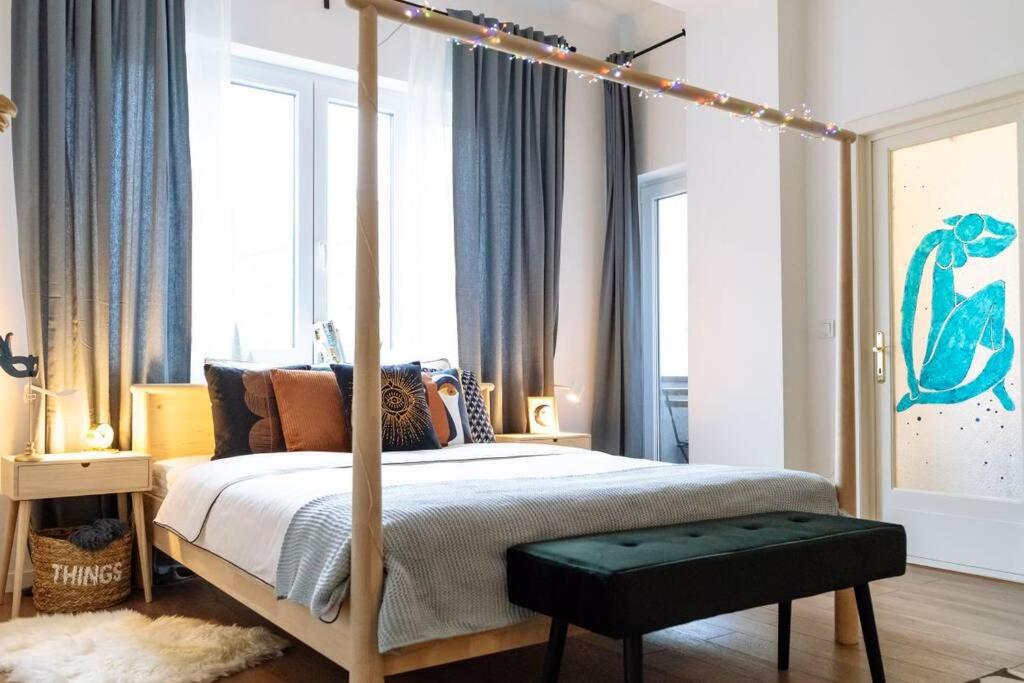 um quarto com uma cama de dossel e um banco verde em La dame bleue em Bucareste