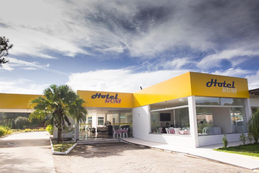 una posada buffet con un edificio blanco y amarillo en Hotel Roni en Itabuna