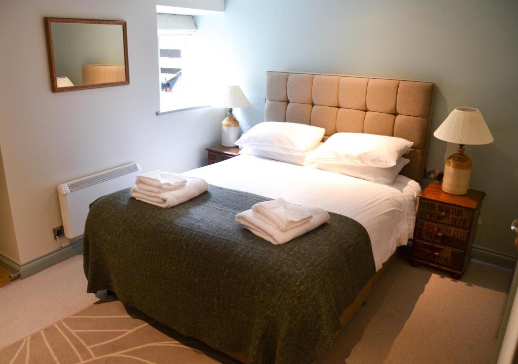 a bedroom with a bed with two towels on it at The Fox in Chipping Norton