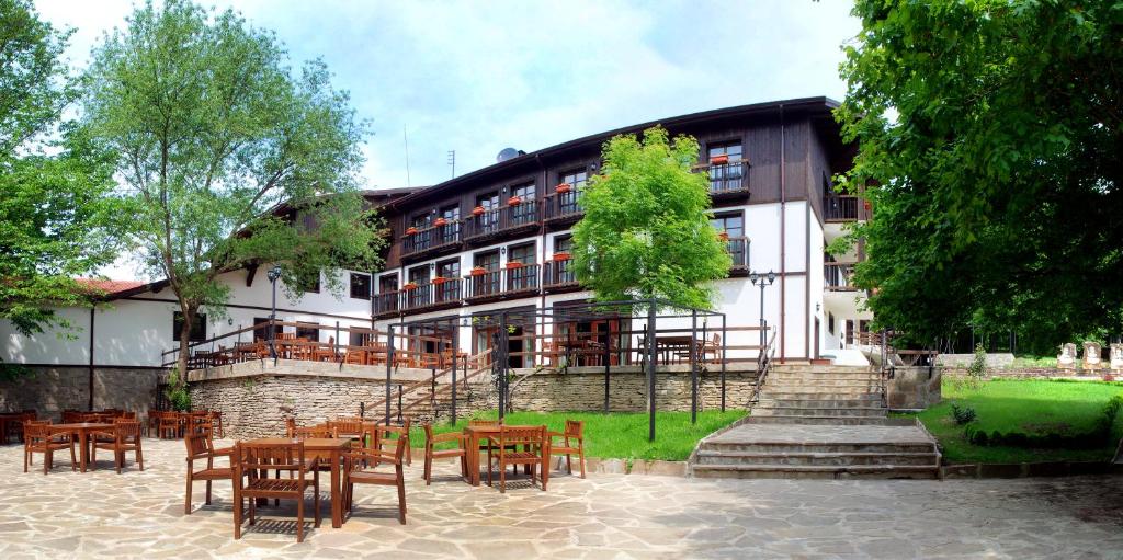 a building with tables and chairs in front of it at Eco Complex Sherba in Debelets