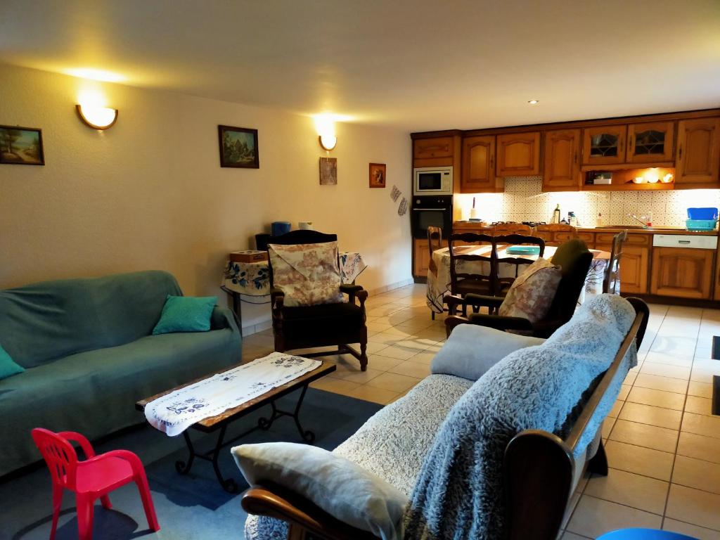 sala de estar con 2 sofás y cocina en La petite maison bleue en Lopérec