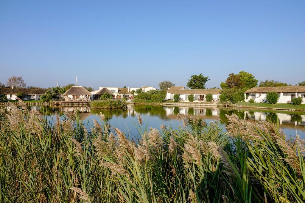 a view of a lake with houses and grass at Hôtel L' Estelle en Camargue in Saintes-Maries-de-la-Mer