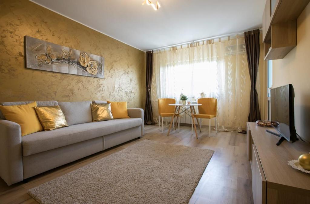 un soggiorno con divano e tavolo di GOLDEN APARTMENT BANEASA a Bucarest