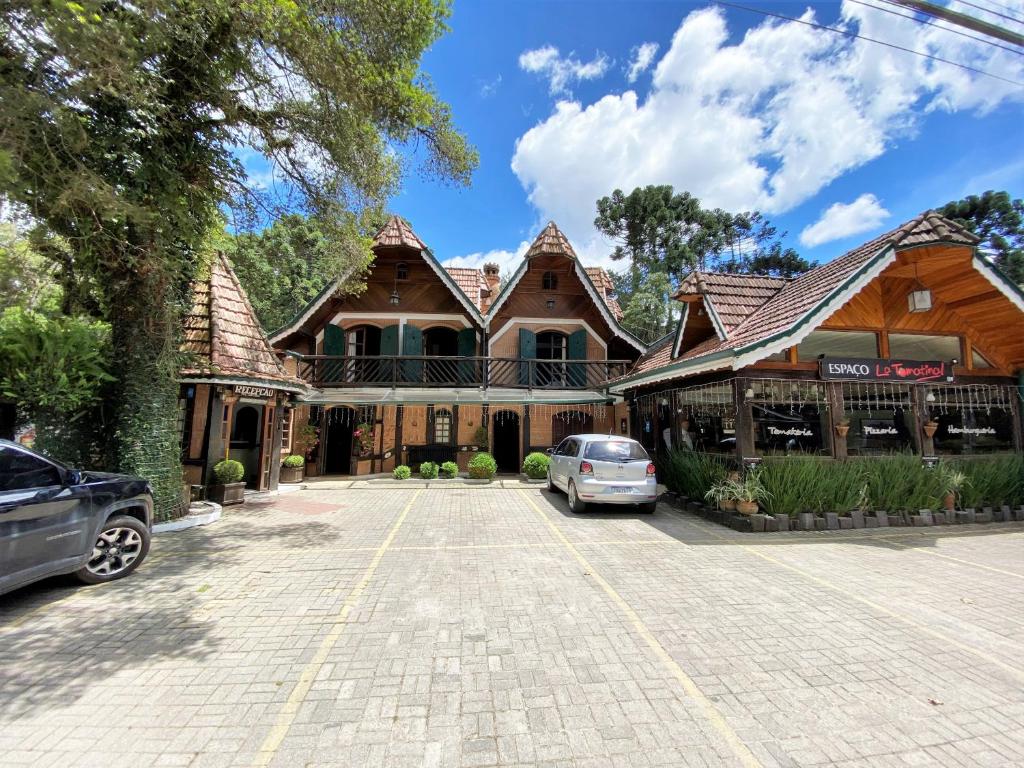 a large house with cars parked in front of it at Pousada do Sino in Campos do Jordão