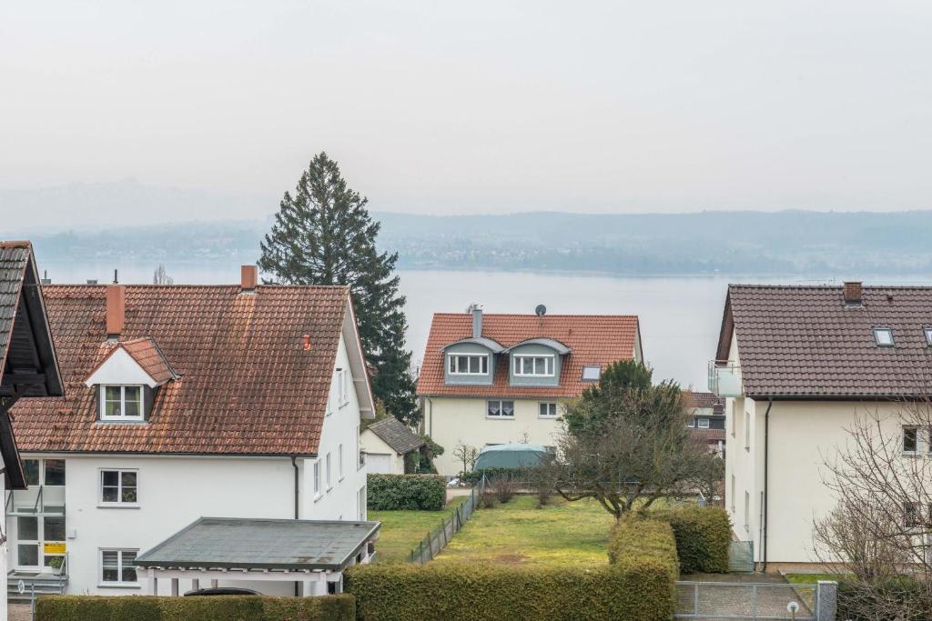 a group of houses with a lake in the background at Ferienwohnung Maria Feucht in Überlingen
