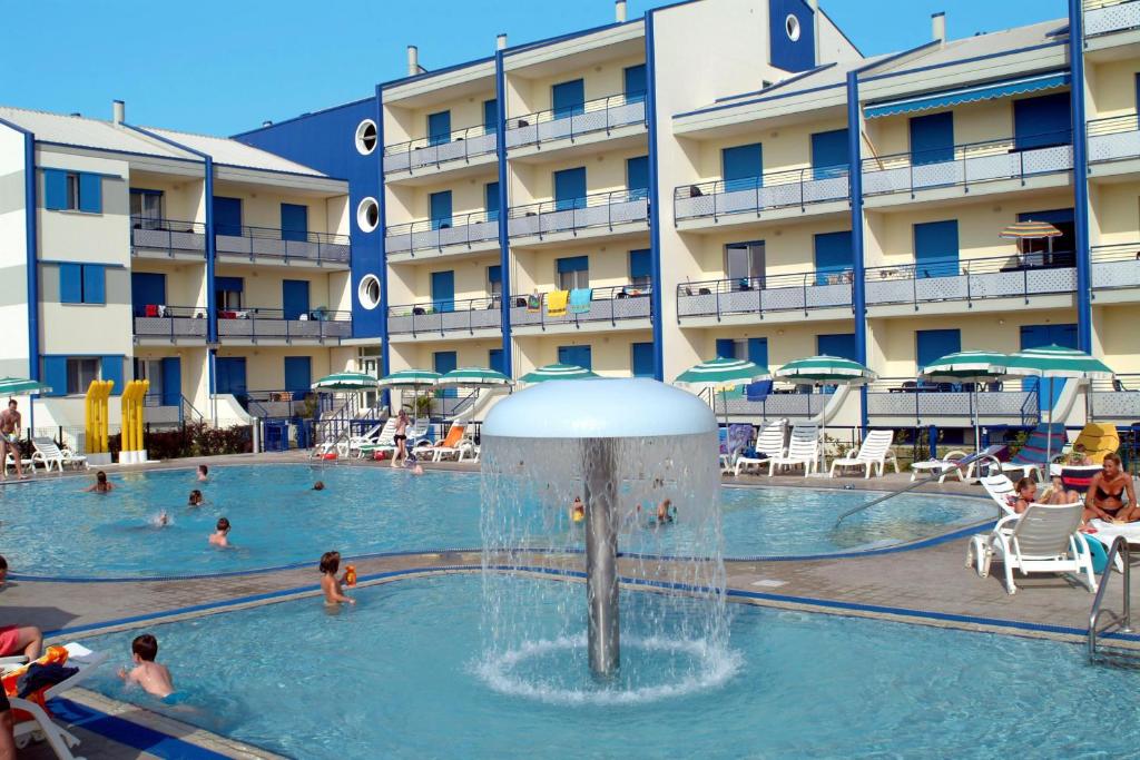a hotel swimming pool with a fountain in front of a hotel at Tamerici Lido Altanea in Caorle