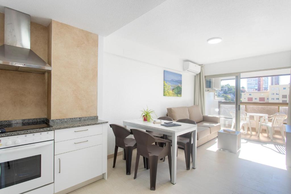 a kitchen and living room with a table and chairs at Aparthotel BCL Levante Club in Benidorm